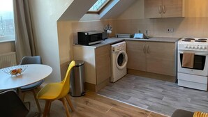 Une cuisine compacte dotée d’un puits de lumière, d’un lave-linge, d’un four à micro-ondes et d’une cuisinière.