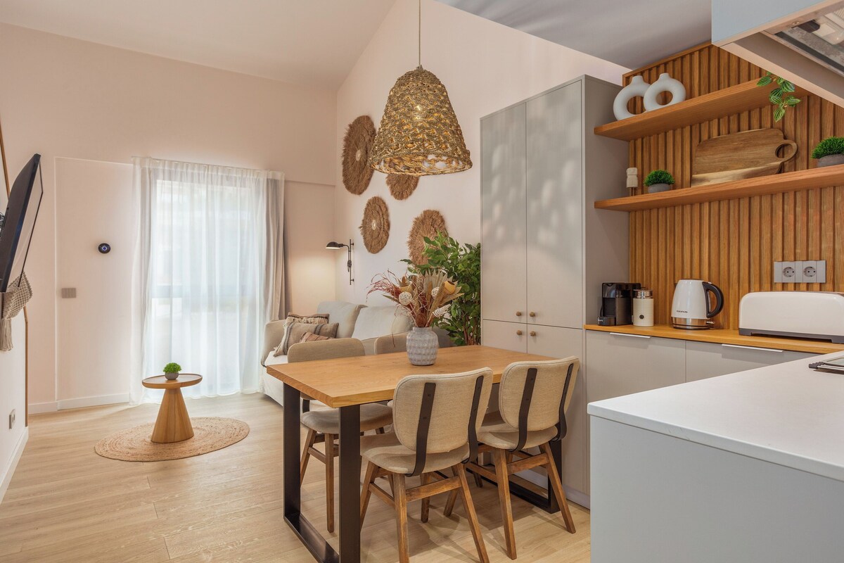 Una cocina moderna con armarios de madera, una zona de comedor con una mesa redonda y una isla de cocina.
