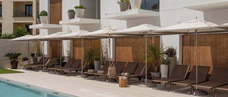 Piscine extérieure, parasols de plage, chaises longues