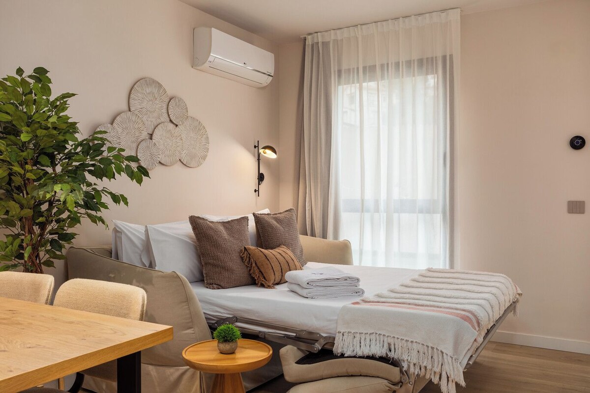 Un dormitorio moderno con cama, mesita de noche y una planta en maceta.