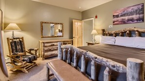 A bedroom with a wooden headboard, a large bed, a wooden dresser, a bench, a mirror, and a painting on the wall. - Expansive townhome, Private hot tub, Great Location, 42BC (Silvethorne)