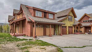 A two-story house with a covered driveway, multiple garage doors, and a large front porch. - Expansive townhome, Private hot tub, Great Location, 42BC (Silvethorne)