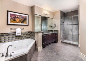 Une salle de bain moderne dotée d’une grande baignoire, d’une douche à l’italienne et d’un meuble-lavabo double.