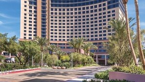 A Wyndham hotel with a modern design, featuring a curved facade and multiple floors. - Wyndham Desert Blue - 1 Bedroom Suite (Las Vegas)
