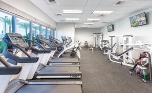 A gym with treadmills, weight machines, and exercise balls.