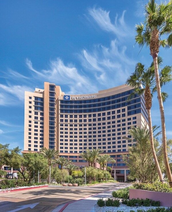 A Wyndham hotel with a modern design, featuring a curved facade and multiple floors.