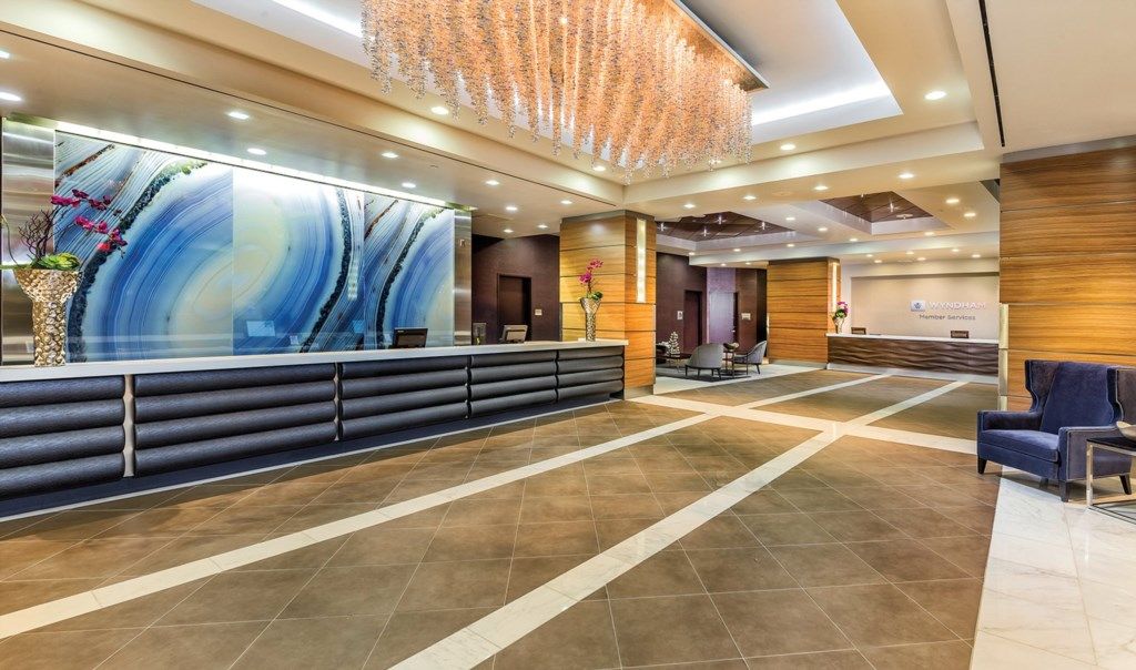 A modern reception area with a long counter, seating, and a decorative ceiling.