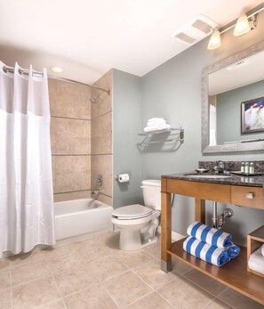 Une salle de bain moderne équipée d’une baignoire, de toilettes et d’un meuble-lavabo.