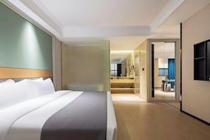 A hotel room with a large bed, a walk-in closet, a bathroom with a mirror, and a TV mounted on the wall. - Haiyi Fino Hotel (Swan Lake Branch) (Jingmen)
