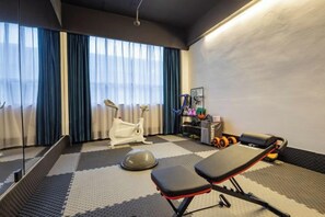 A room with a massage chair, a stationary bike, and a small exercise area. - Haiyi Fino Hotel (Swan Lake Branch） (Jingmen)