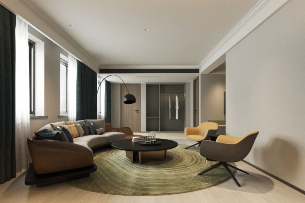 A modern living room with a sofa, armchairs, a coffee table, and a large window.