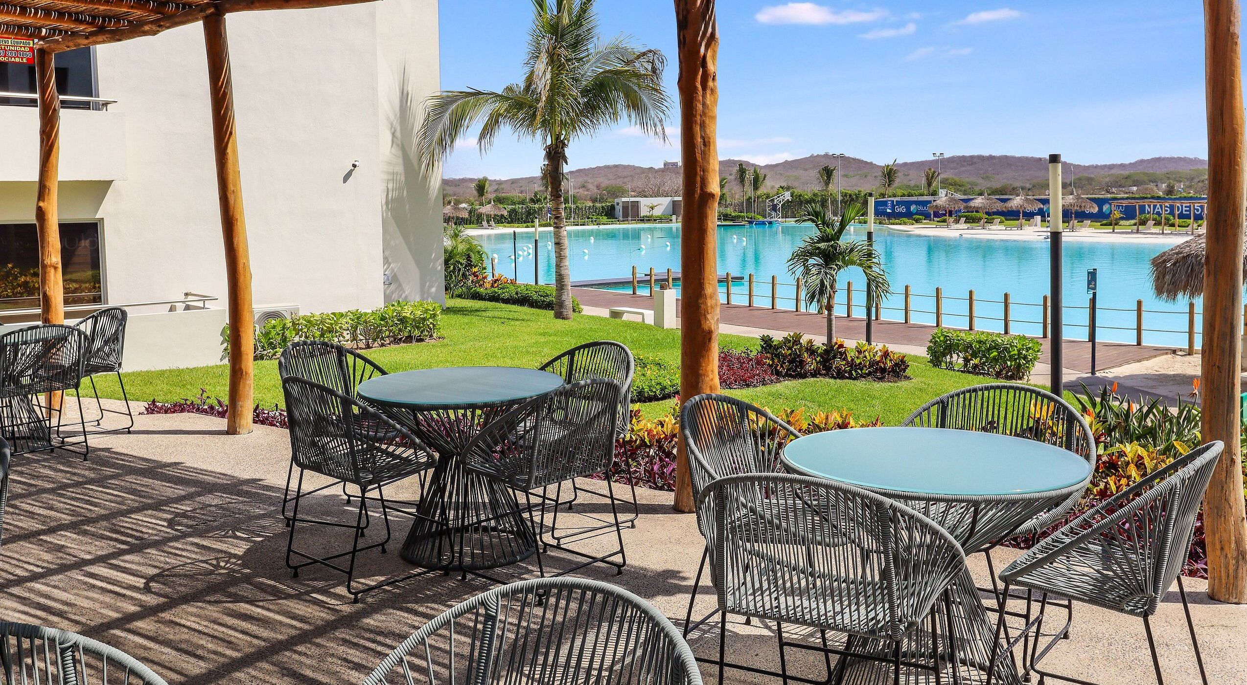 Un patio con mobiliario exterior y vistas a una piscina.