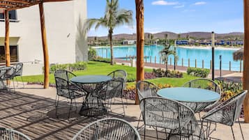Un patio con mobiliario exterior y vistas a una piscina.