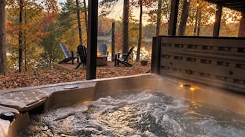 Ein Whirlpool mit Blick auf einen Wald und Stühlen.