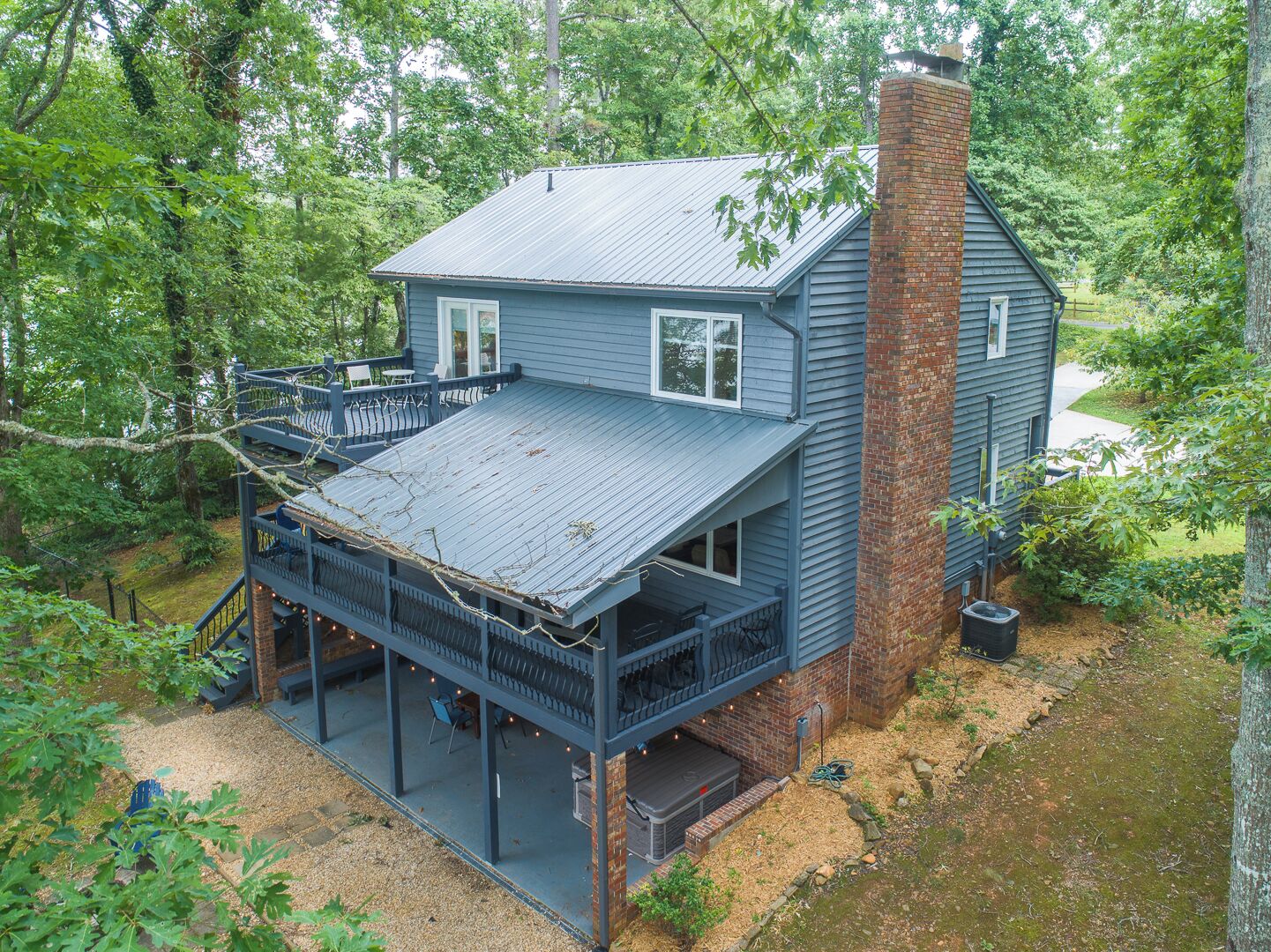 A two-story house with a porch and a brick chimney.