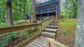 A wooden staircase leading to a building with a balcony, surrounded by trees. - 4BR Lake House w/ Private Dock, Hot tub, and Lake Views! (Blairsville)