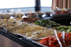 A buffet with various food items including rice, cheese, and vegetables.