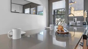 Un baño moderno con un espejo grande, una bañera y un tocador elegante.