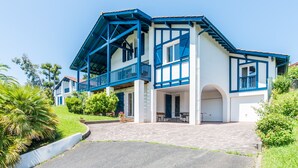 Ein zweistöckiges Haus mit Balkon, Garage und befestigter Auffahrt.