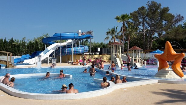 A swimming pool area with multiple water slides and a large starfish decoration. - Mobil Home/bungalow 6 Places Camping 4 (Hyères)