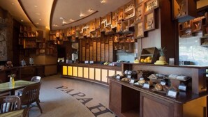 A hotel lobby with a curved reception desk, a seating area with chairs, and a wall decorated with framed items. - Ko Olina | Romantic Disney Retreat | Lagoon + Pool (Kapolei)