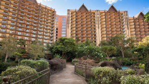 A hotel with multiple high-rise buildings, a central pathway, and a landscaped garden with rock formations and trees. - Ko Olina | Romantic Disney Retreat | Lagoon + Pool (Kapolei)