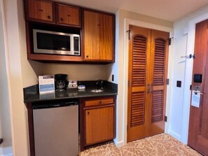 A compact kitchen with a microwave, coffee maker, and dishwasher.