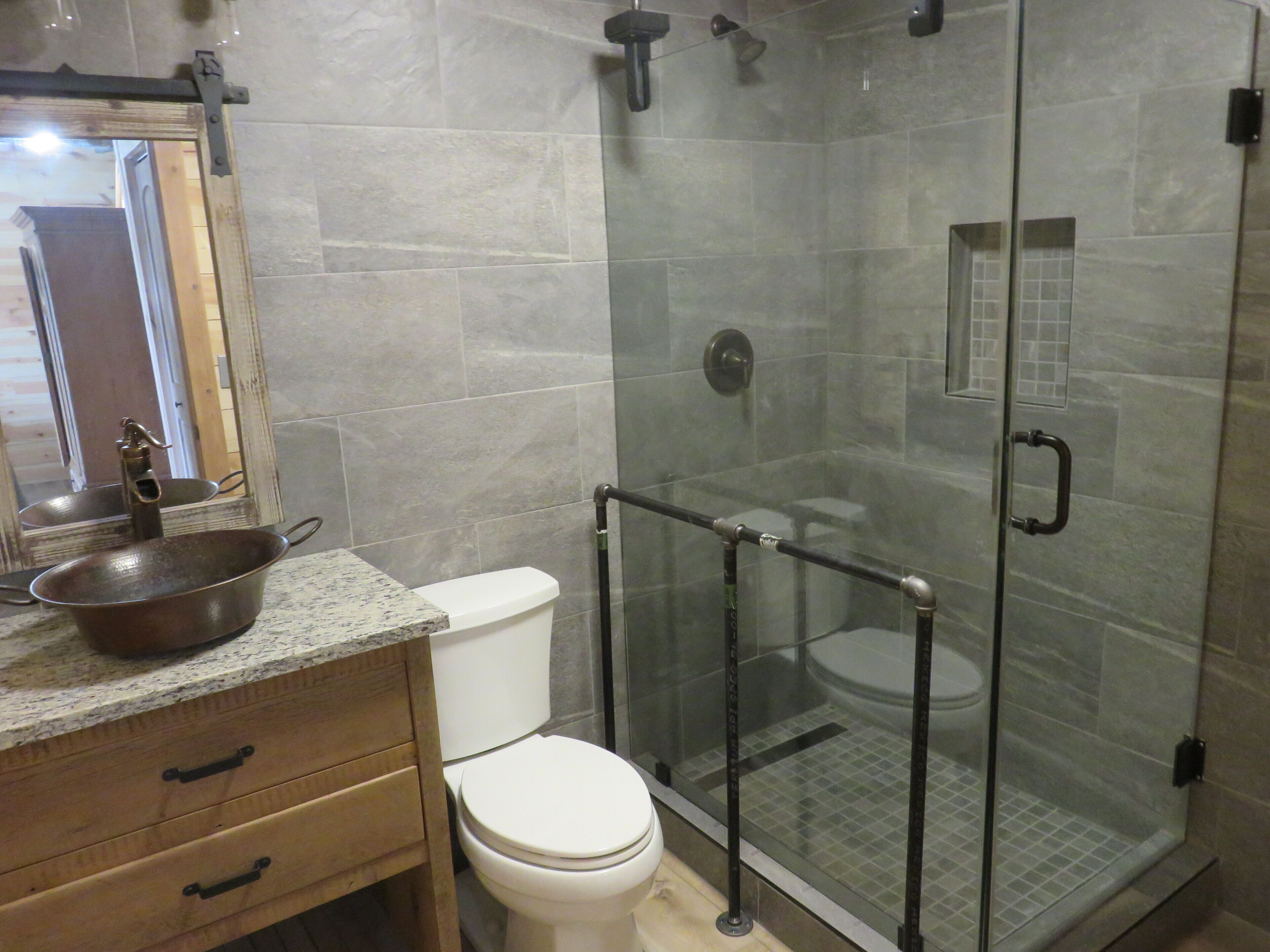 Une salle de bain avec une douche à parois de verre, un lavabo et des toilettes.
