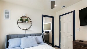 A bedroom with a bed, a dresser, a mirror, and a wall-mounted shelf with plants. - Notre Dame Home Steps to Campus w/ Hot Tub (South Bend)