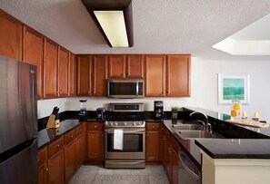 Enjoy cooking in this well-equipped kitchen with a refrigerator, microwave, oven, sink, and coffee maker.