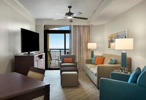 Relax in a stylish room with a flat-screen TV, comfortable seating area, and a large window offering a view of the outdoors.