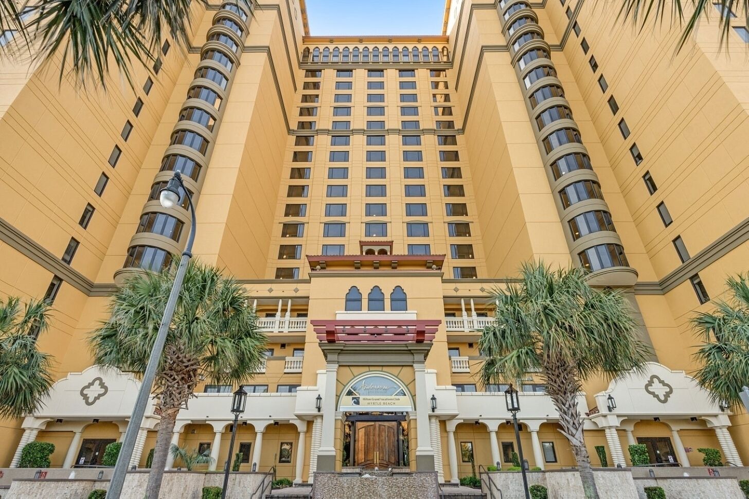 A multi-story hotel with a symmetrical facade, large windows, and a central entrance with a decorative archway.