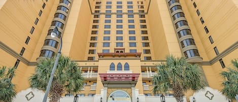 A multi-story hotel with a symmetrical facade, large windows, and a central entrance with a decorative archway.