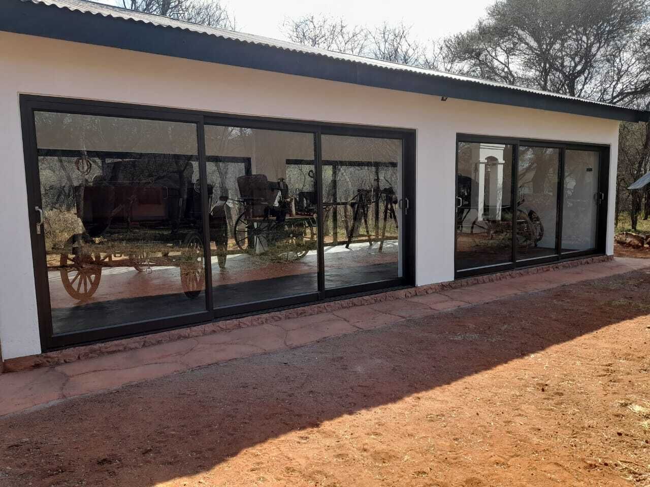 Un edificio moderno con amplios ventanales de vidrio y suelo de tierra.