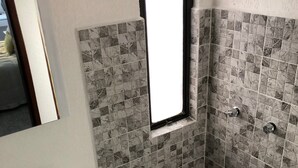 Ein Badezimmer mit Dusche, Waschbecken und Spiegel.