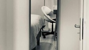 A narrow doorway with a mirror reflecting a bed and a chair. - Cosy & New 2 bedrooms in Center  (Luxembourg City)