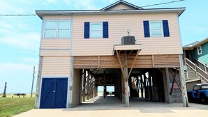 Un edificio a due piani con un portico coperto e un'anta di garage blu.