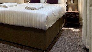 A hotel room with a large bed, two bedside tables, and a headboard with built-in lighting. - The Old Farm Hotel (Birmingham)
