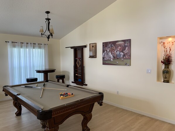 A pool table with a cue stick, a billiards rack, and a vase with dried plants. - Minutes to Disney! Spacious 3BR Family Home w/ POOL! Pool Table & Themed Rooms! (Kissimmee)
