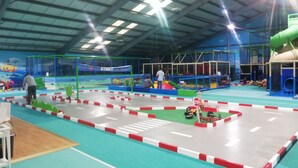 An indoor play area with a road layout, play structures, and a green slide. - Jasmunder Inselglück vacation apartment for 4 people on Rügen - Jasmund (Sagard)