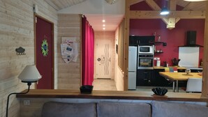 A cozy kitchen with wooden cabinets, a microwave, and a refrigerator. - Maison Chaleureuse Avec Piscine Entre Montagne ET MER (ASCAIN)