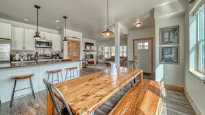 A spacious kitchen with white cabinets, a wooden island, and pendant lighting. - Silver Rush- Brand New Railyard home minutes to Copper & Ski Cooper! (Leadville)