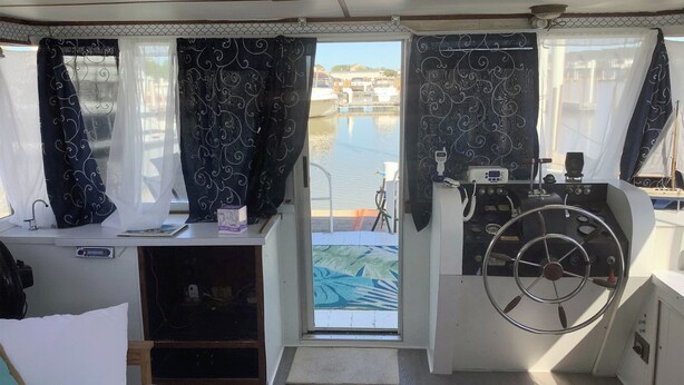 Una cabina compatta con una piccola scrivania, una panca imbottita e un volante.