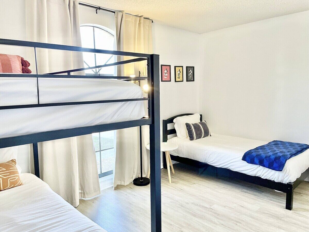 A room with bunk beds, a single bed, and a small table.