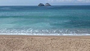 A beach with clear turquoise water and a distant rocky island. - Oasis en Centro Histórico Alberca Playa 3 mins (Mazatlán)