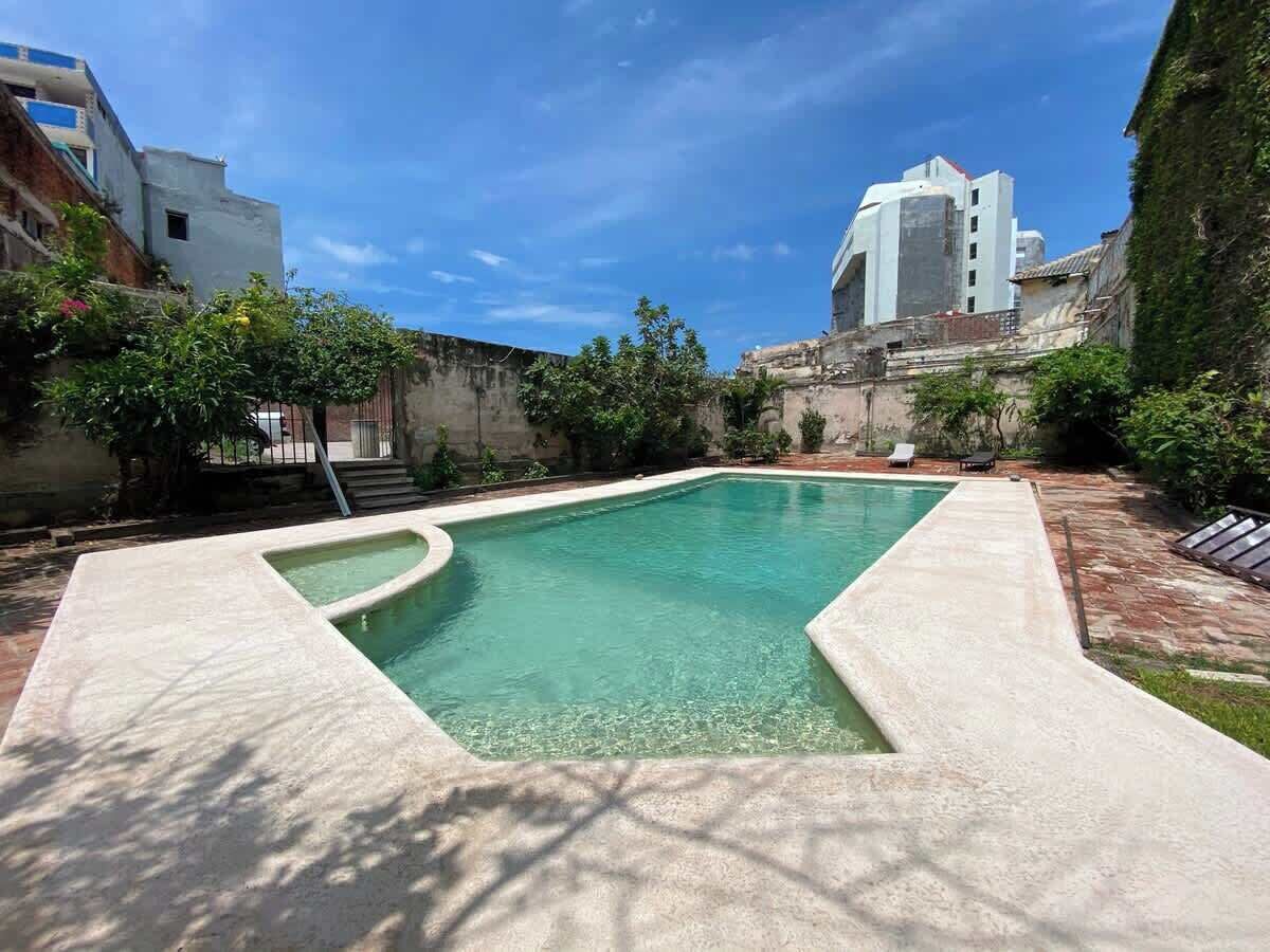 Ein rechteckiger Pool mit klarem, blauem Wasser, umgeben von einer Betonplattform.