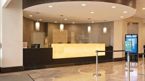 Una zona de recepció amb un taulell de fusta, lluminàries i un cartell de FantaSea Resorts.