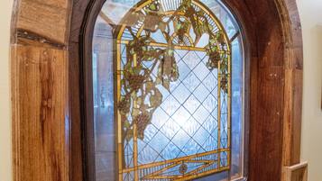 A wooden-framed stained glass window with a geometric pattern.