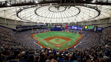 Un stade de baseball doté d’un grand toit circulaire et de plusieurs niveaux de gradins.