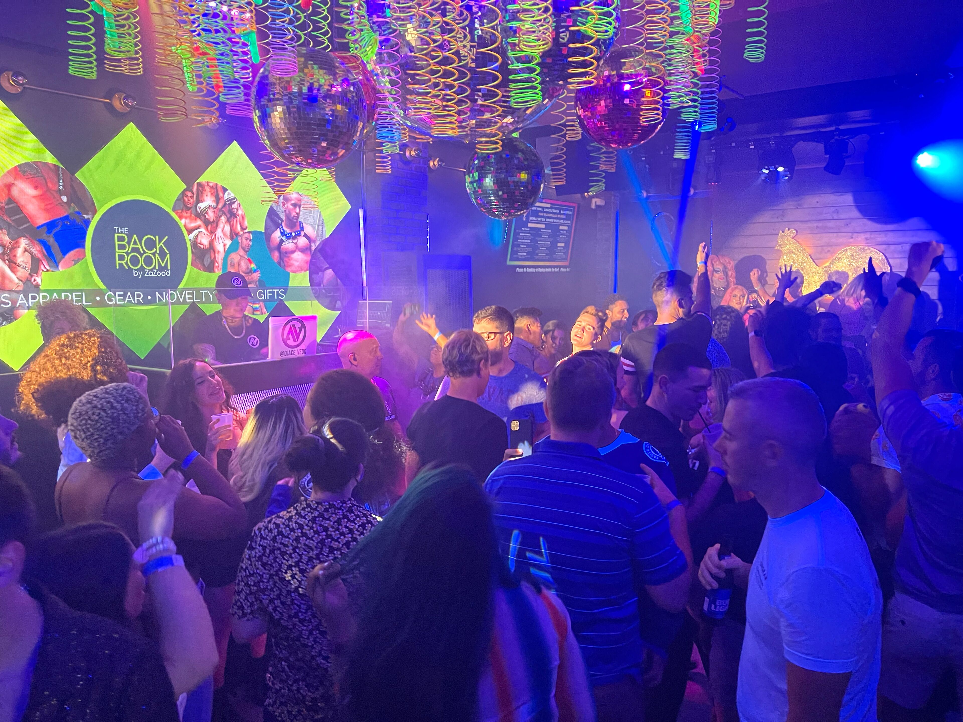 Una discoteca affollata con luci al neon e palle da discoteca.